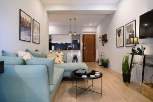 a living room with a blue couch and a table at Cosy Contemporary Luxury Urban Retreat in Athens in Athens