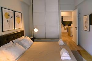 a bedroom with a bed with two white towels on it at Cosy Contemporary Luxury Urban Retreat in Athens in Athens