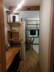 een keuken met een koelkast, een tafel en een raam bij Apartamentai 78 in Mažeikiai