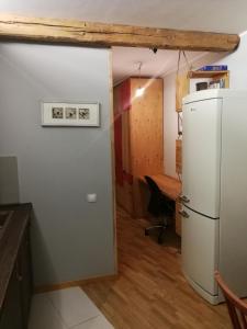 een keuken met een witte koelkast en een tafel bij Apartamentai 78 in Mažeikiai