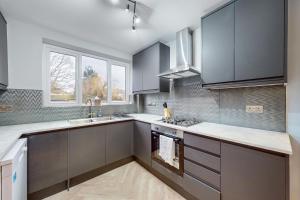 a kitchen with gray cabinets and a sink at Brand New 3BDR with Garden&Free Parking in Hendon in Hendon