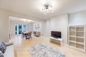 a living room with a television and a dining table at Brand New 3BDR with Garden&Free Parking in Hendon in Hendon