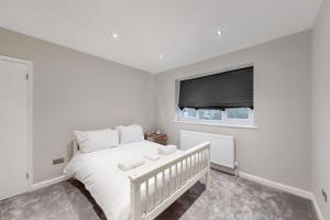 a white bedroom with a white bed and a window at Brand New 3BDR with Garden&Free Parking in Hendon in Hendon