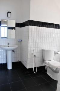 a white bathroom with a sink and a toilet at Sea View Hotel in Colombo