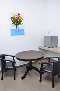 a table and two chairs and a table with a picture at Sea View Hotel in Colombo