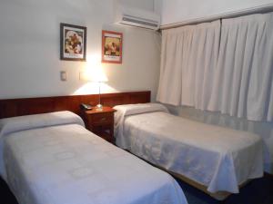 a hotel room with two beds and a window at Hotel Monterrey in Termas de Río Hondo