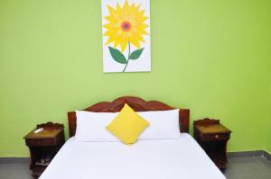 a bedroom with a bed with a flower painting on the wall at Sea View Hotel in Colombo