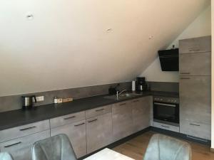 a kitchen with stainless steel cabinets and a sink at Ferienwohnung Brennerei Stilling in Bad Mergentheim +2 photos