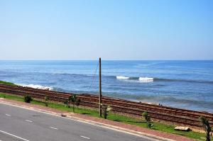 an empty road next to the ocean with waves at Sea View Hotel in Colombo