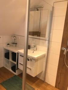 Ferienwohnung Brennerei Stilling في باد ميرجينثيم: حمام أبيض مع حوض ومرآة