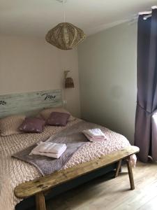 a bedroom with a bed with two towels on it at Le Burin des Rosiers in Olby
