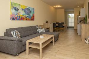 a living room with a couch and a table at Seewohnung "Riems" in Gützkow