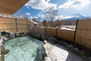 a swimming pool with a fence and a mountain at GEN.（富士クラシックホテル） in Fujikawaguchiko