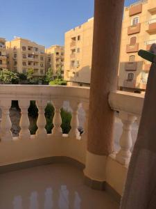 balcón con barandilla blanca y algunos edificios en Apartment in Gardenia compound, en Madīnat Sittah Uktūbar