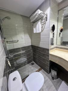 a bathroom with a toilet and a shower and a sink at Zaha Al Madina Hotel in Al Madinah