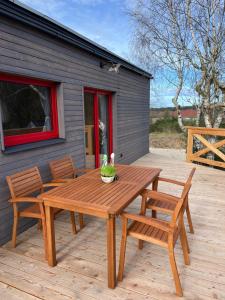 a wooden table and chairs on a deck with a building at Pension U Stříbrného Jelena - Tiny House in Cheb