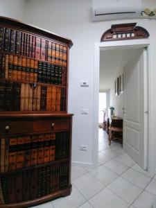 a room with a large wooden book shelf filled with books at Mansarda di Masha in Villongo SantʼAlessandro