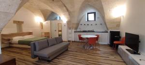 1 dormitorio con cama, mesa y cocina en La Stalla, en Gravina in Puglia