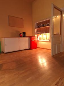 eine Küche mit roten und weißen Schränken und einem Kühlschrank in der Unterkunft Alte Volksschule Raiding in Raiding