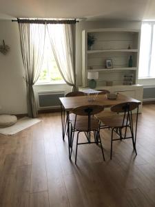 a dining room with a table and chairs and a window at Le Burin des Rosiers in Olby