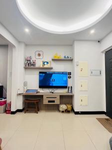 a living room with a desk with a large screen tv at Pengjia Villa in Hengchun South Gate