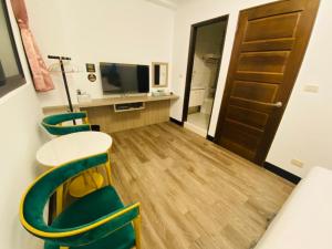 a room with a table and chairs and a television at Pengjia Villa in Hengchun South Gate