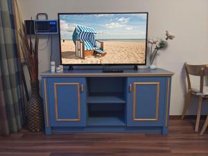 einen TV auf einem blauen Schrank in der Unterkunft Yachthafenresidenz - Wohnung 9102 / 878 in Kühlungsborn