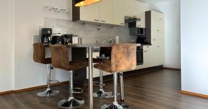 a kitchen with a bar with wooden stools at streitbergers. Appartement in Maishofen