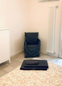 una sala de estar con una silla y una bandeja en el suelo en Piccola Corte en Udine