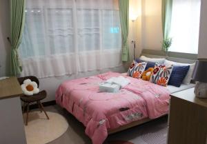 - une chambre avec un lit rose et une fenêtre dans l'établissement The hand flower home, à Chum Phae