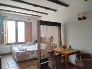 1 dormitorio con 1 cama y 1 mesa con sillas en Alojamientos La Dehesa en El Berrueco