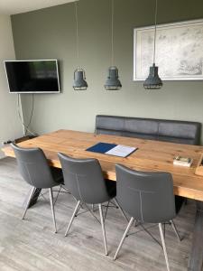 Vissers Huus Hollum Ameland في هولوم: قاعة اجتماعات مع طاولة وكراسي خشبية