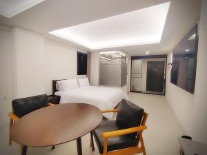 um quarto com uma cama, uma mesa e cadeiras em 인천 연수 블루버드호텔 Bluebird Hotel em Incheon
