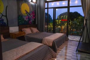 a hotel room with two beds and a large window at Phúc Hưng Kazin Homestay Ba vì in Ba Vì