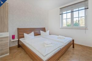 a bedroom with a bed with white sheets and a window at Ferienwohnung Sonneneck in Kachlin