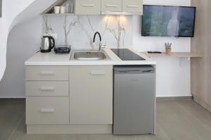 a white kitchen with a sink and a microwave at AR APARTMENTS in Nikiti