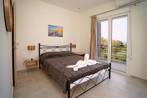 una camera da letto con un letto e un asciugamano bianco di Karnagio Rooms a Kyparissia