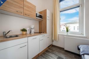 een keuken met witte kasten en een raam bij Villa Seeland Villa Seeland App 3 in Heringsdorf