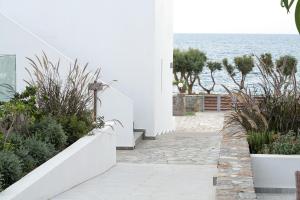 a white building with plants and the ocean in the background at Maritimo Beach Hotel in Sissi