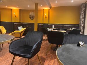 un restaurant avec des chaises noires, des tables et des chaises jaunes dans l'établissement Logis Hotel Center, à Brest