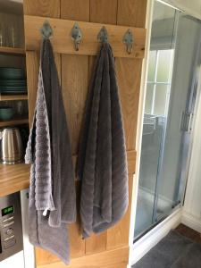 a bathroom with towels hanging on a wall at Green Valley, Cotswold stay with hamper in Cheltenham +16 photos