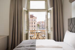 プラハにあるNOBILIS RESIDENCEのベッドルーム1室(ベッド1台付)、窓(テーブル付)