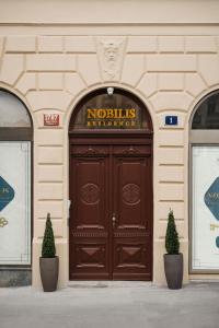 eine große Holztür an einem Gebäude mit einem Schild darüber in der Unterkunft NOBILIS RESIDENCE in Prag