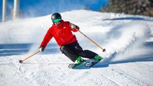 a man is skiing down a snow covered slope at Huvila Hukanhuippu in Syöte