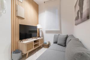 Il comprend un salon doté d'un canapé et d'une télévision à écran plat. dans l'établissement Modern and cozy-1Bedroom 1Bathroom-Azca, à Madrid