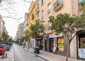 une rue urbaine avec des bâtiments, des arbres et des voitures dans l'établissement Modern and cozy-1Bedroom 1Bathroom-Azca, à Madrid