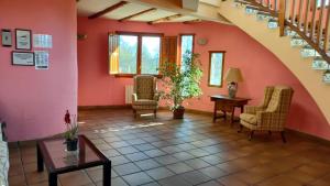 una sala de estar con paredes y sillas rosas y una mesa. en Alojamientos La Dehesa, en El Berrueco 37 fotos más