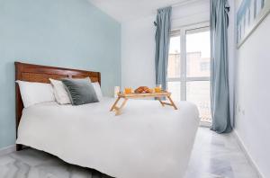 マラガにあるGuadalmedina Riversideのベッドルーム(白い大型ベッド、テーブル付)