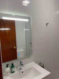 bagno con lavandino e specchio di Modern and airy holiday home a Torrevieja