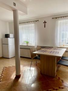 a kitchen with a table and a cross on the wall at Domek u Kacpra in Jeleśnia